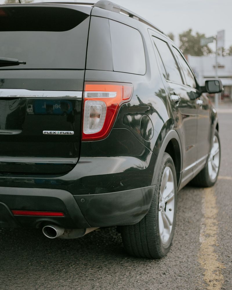 Rear corner of a black Ford Explorer with the tail lamp and liftgate edge