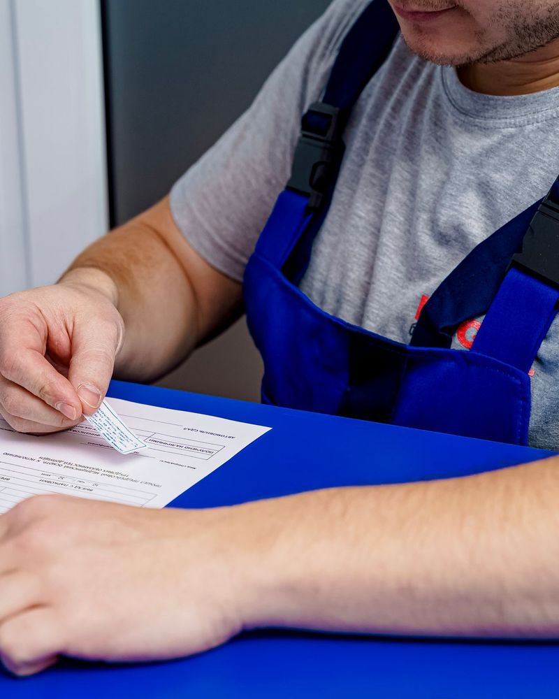 Technician filling in a repair form at a service desk